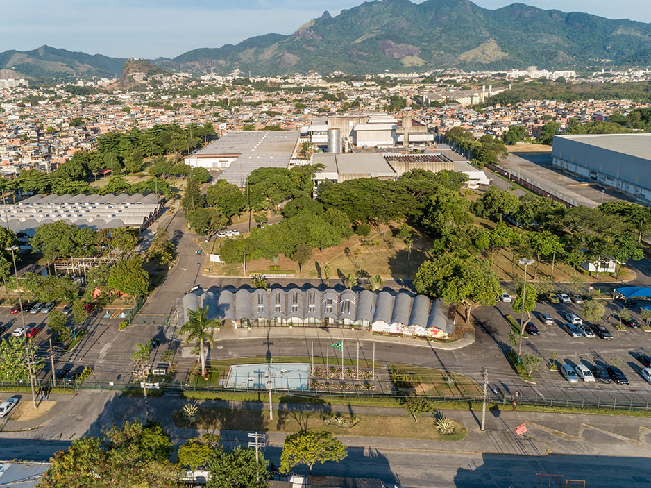 fotografia aérea de área industrial com galpões, árvores e local de estacionamento