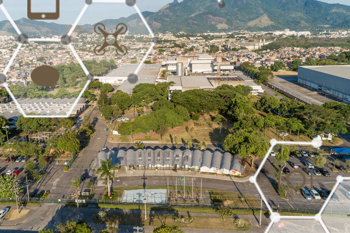fotografia aérea de área industrial com galpões, árvores e local de estacionamento